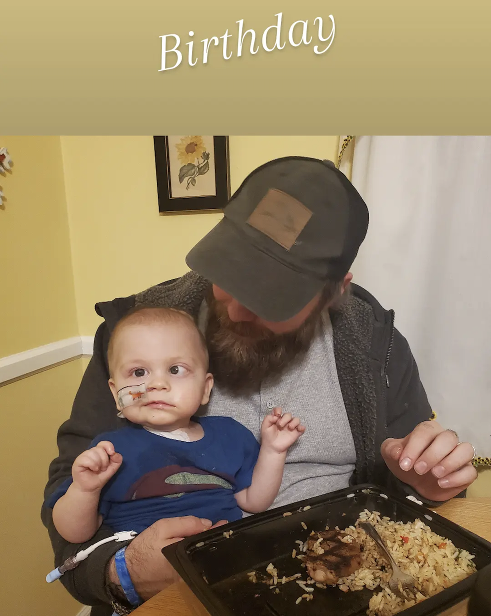 Baby boy enjoying dinner on his dads lap