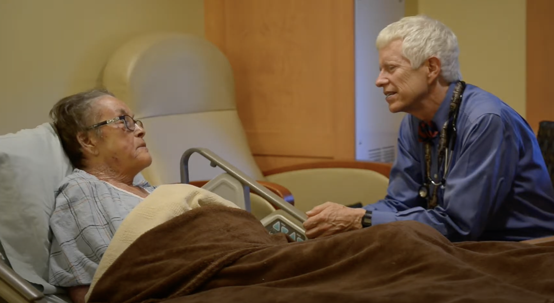 Doctor sitting with a patient at bed side