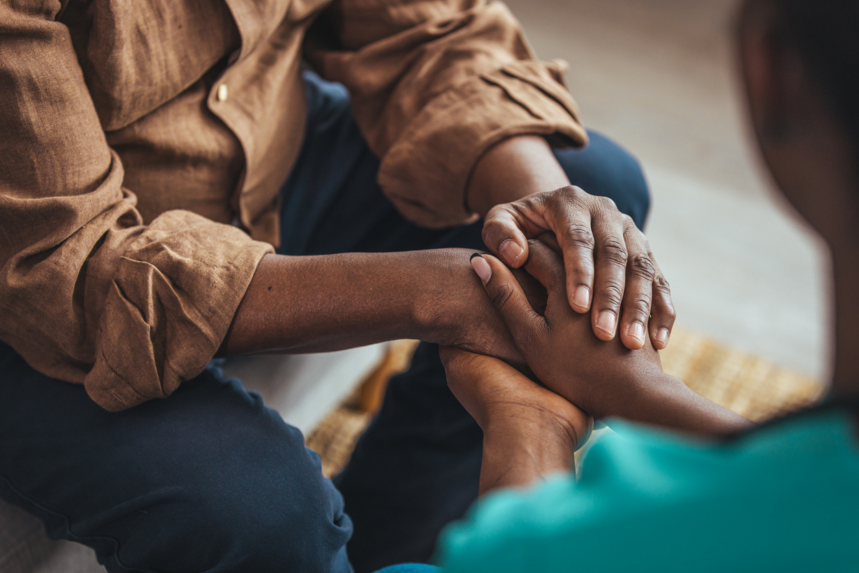 Closeup of a support hands from a social worker. Closeup shot of a young woman holding a senior man's hands in comfort. Female carer holding hands of senior man