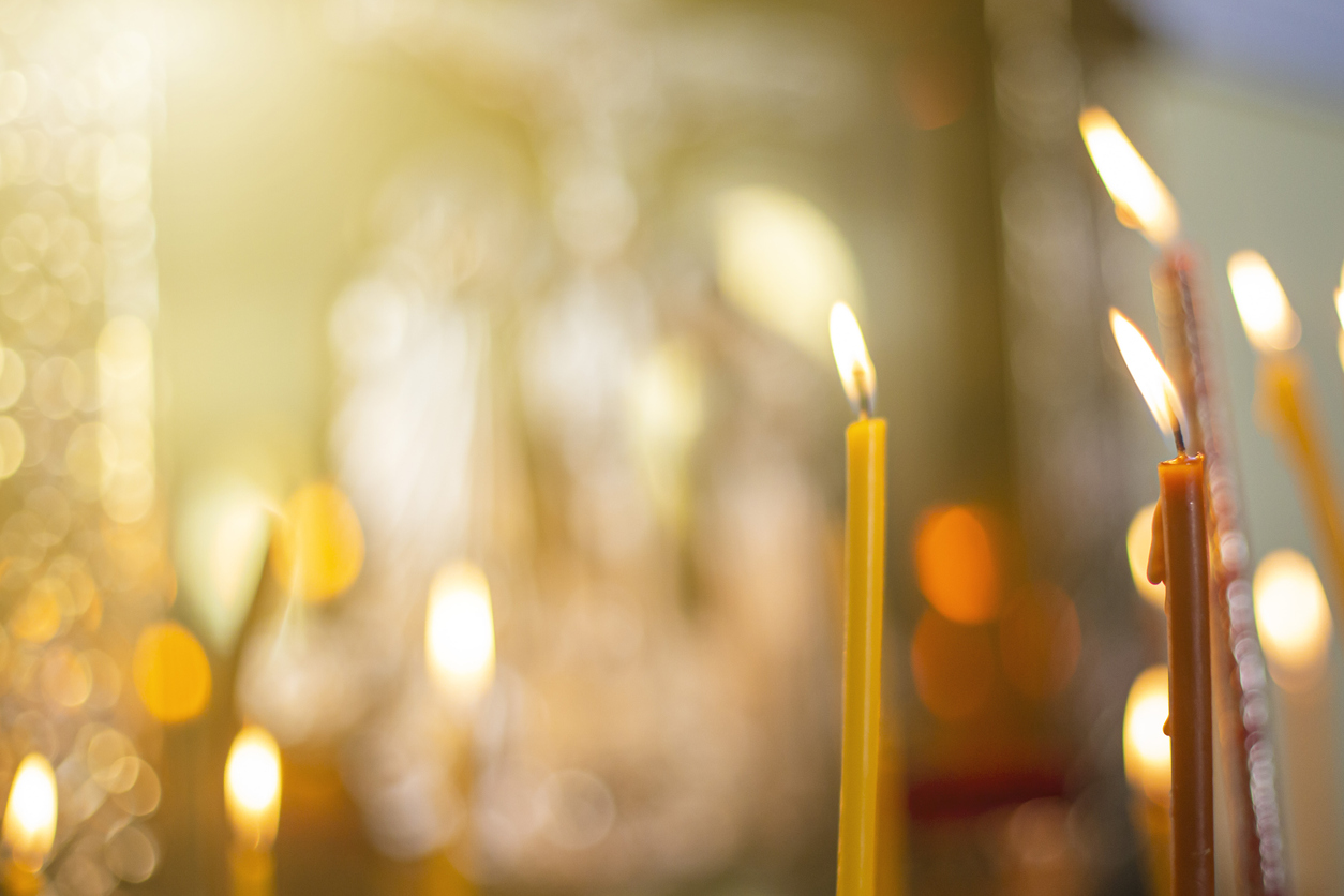 church candles close-up, against the background of a specially blurred religious cross