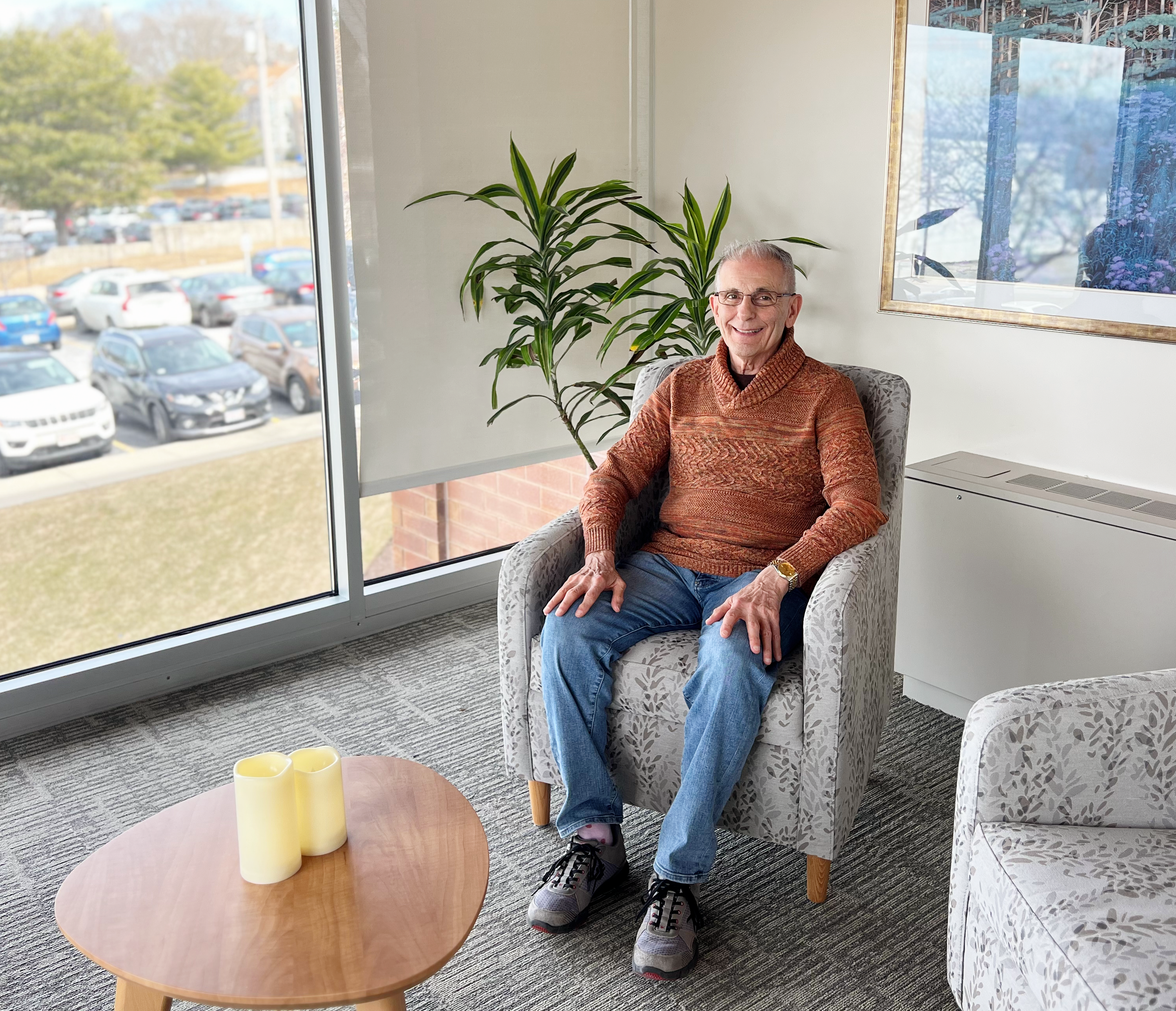 Male hospice volunteer shares his journey from caregiver to volunteering. He's sitting in a tranquil room