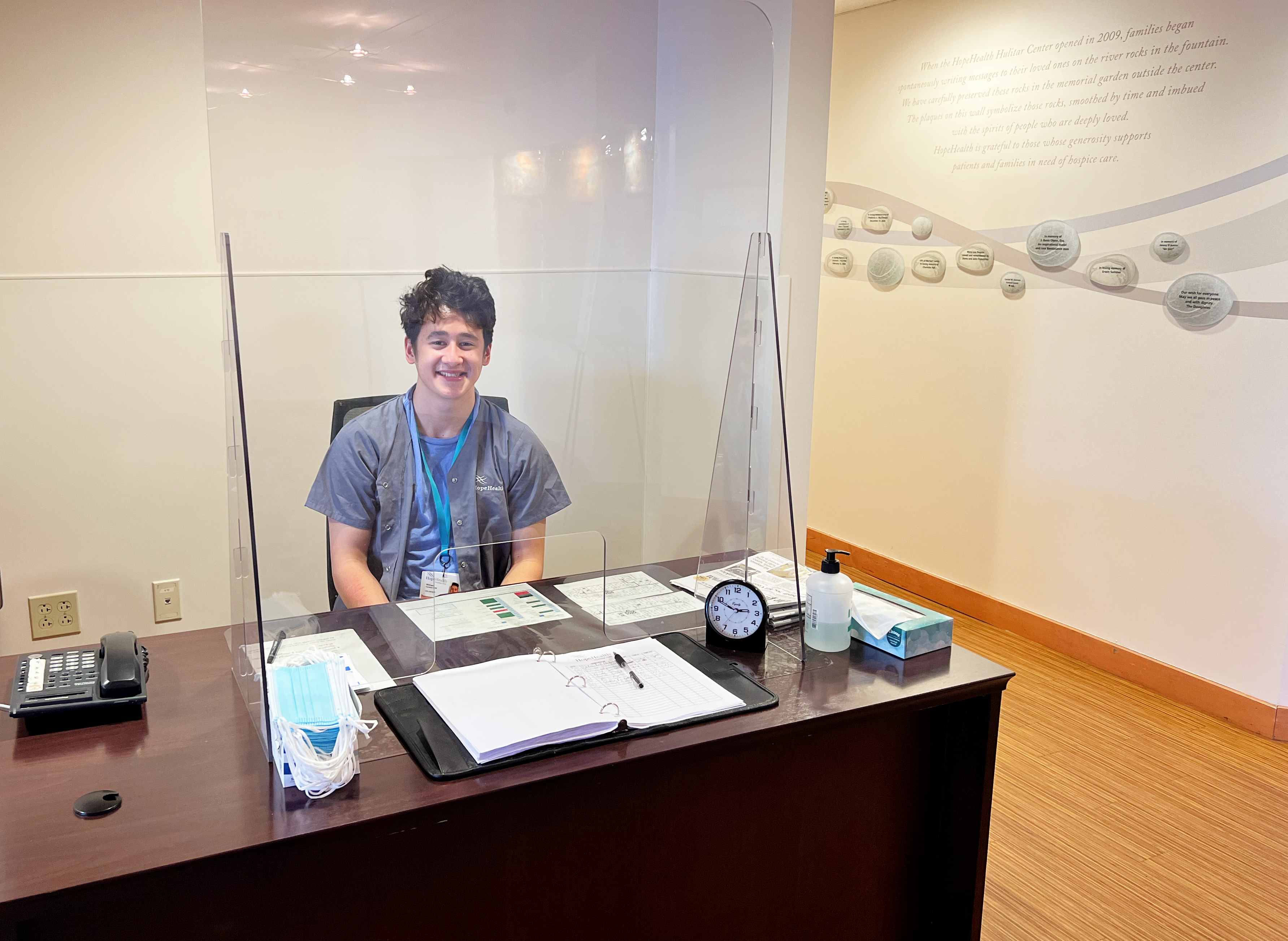 Young man at the greeter's desk of the Hulitar Hospice Center