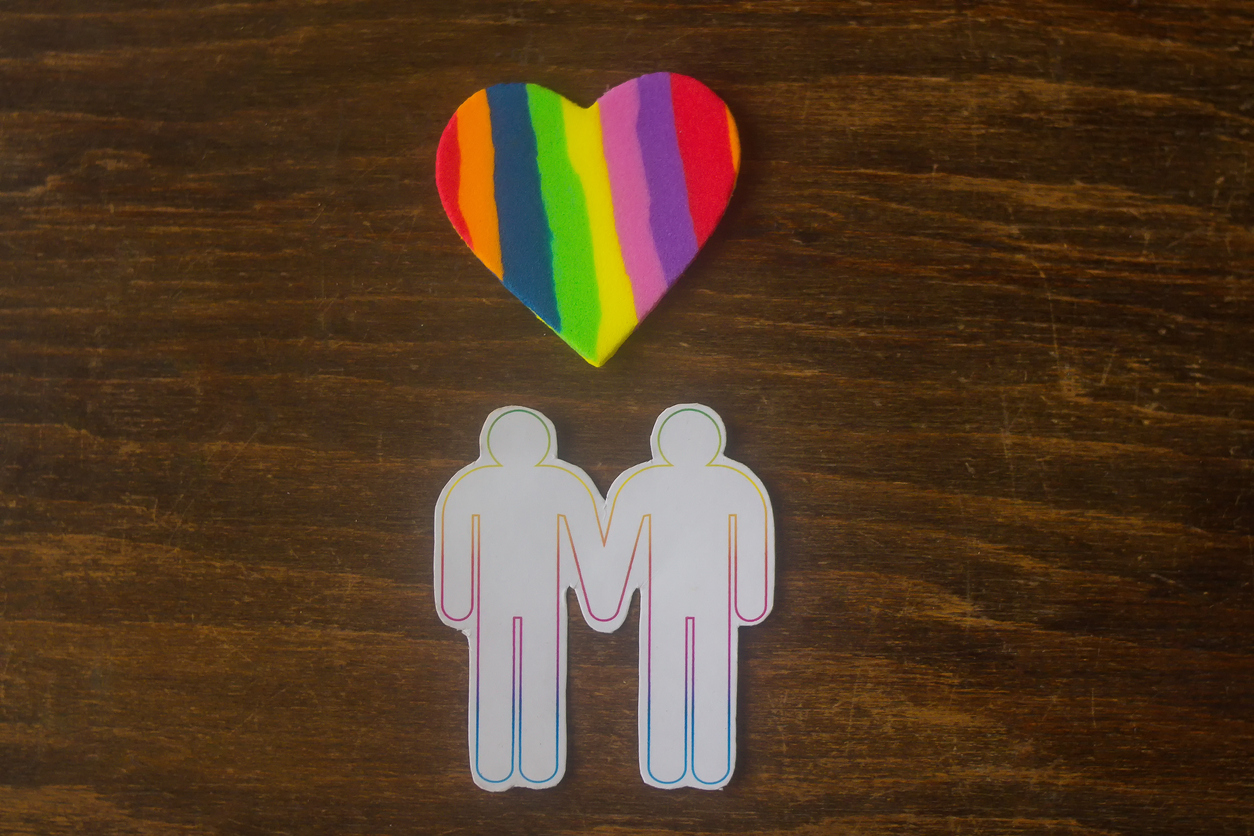 gay couple and a multicolored heart - closeup