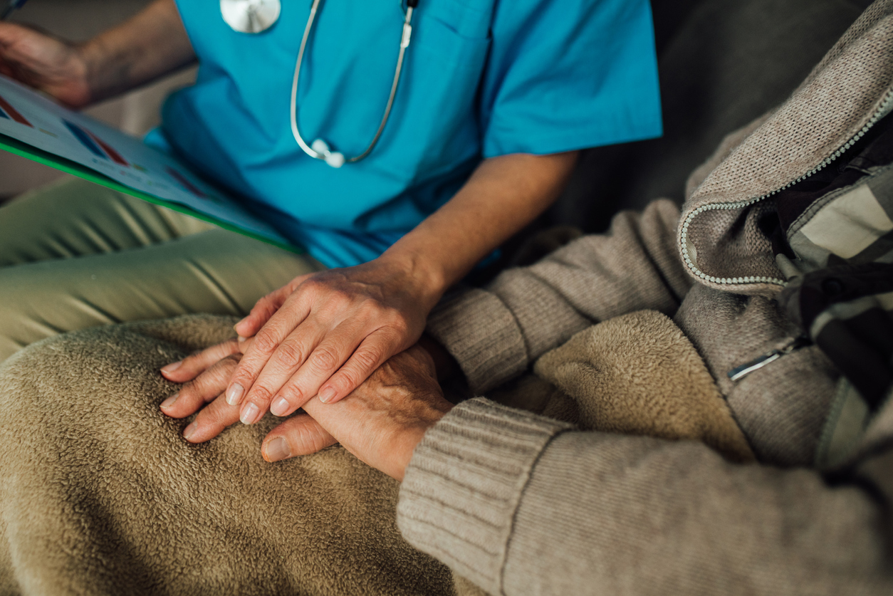 Male patient holding hands with a nurse