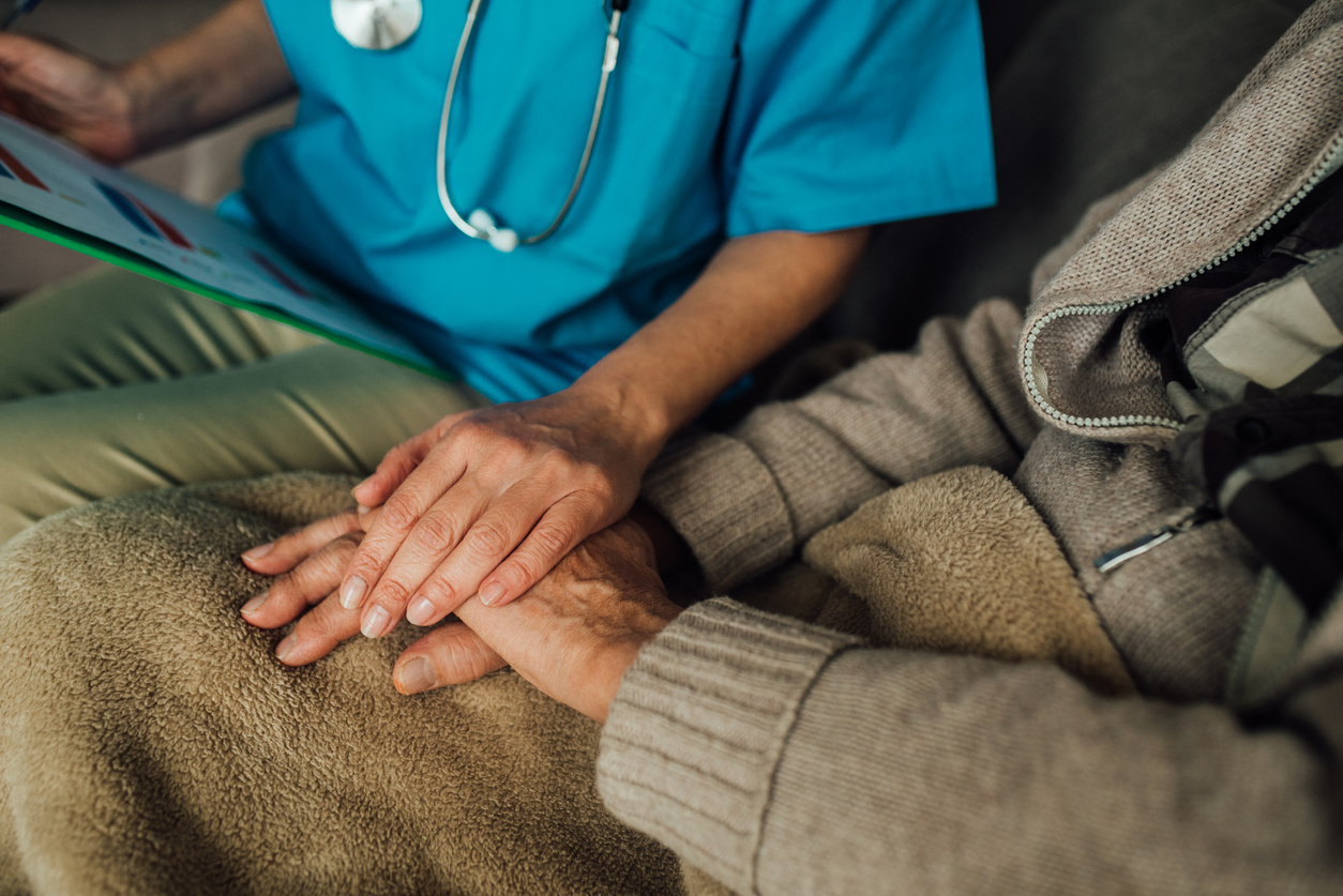 Male patient holding hands with a nurse