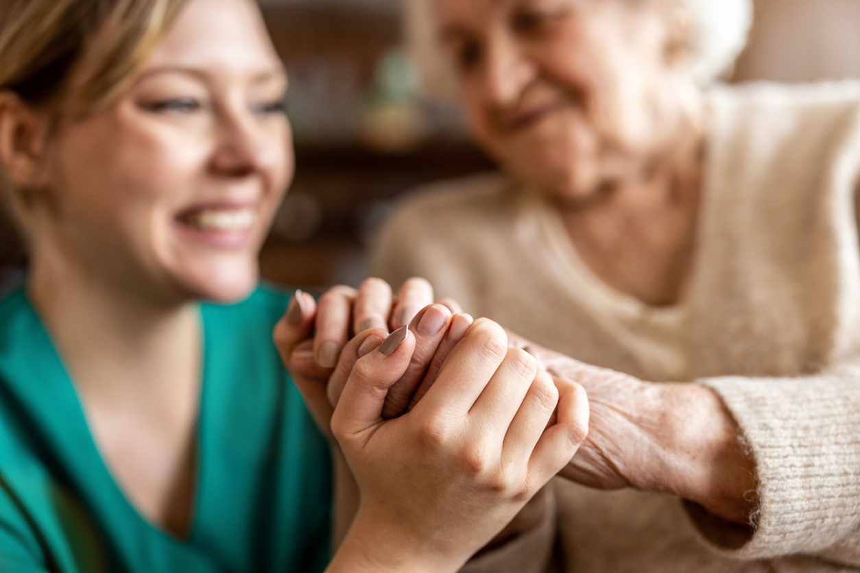 Cropped shot of a senior woman holding hands with a nurse