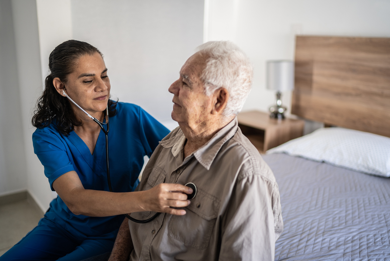 Nurse listening senior heartbeat at home