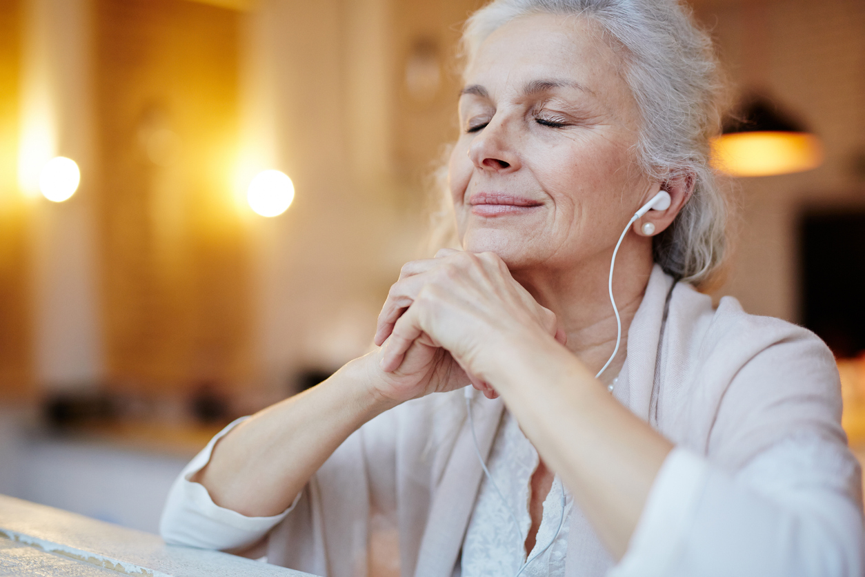 Mature woman with earphones listening to music