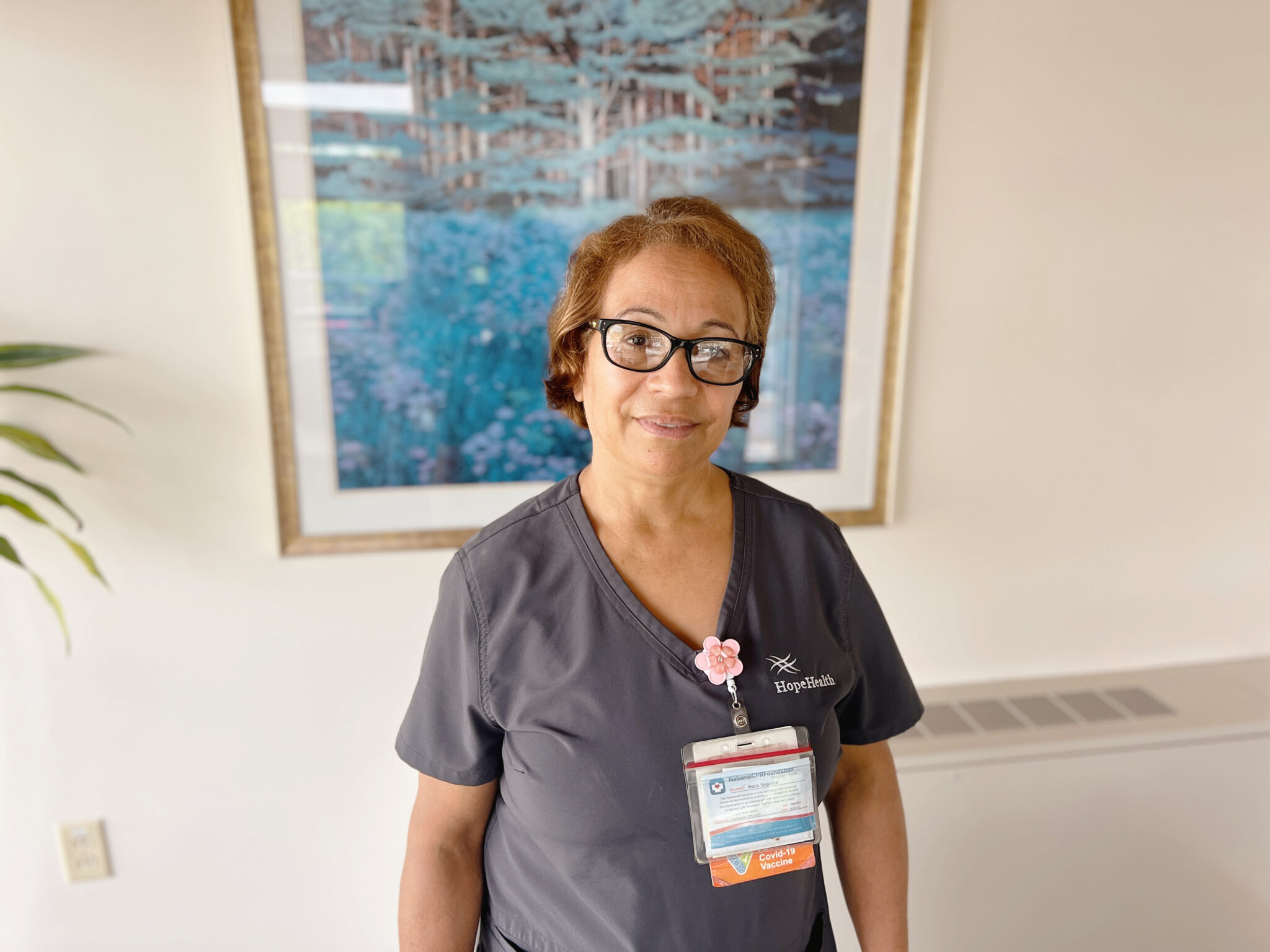 CNA in gray scrubs smiles warmly with compassion in the Hulitar Hospice Center