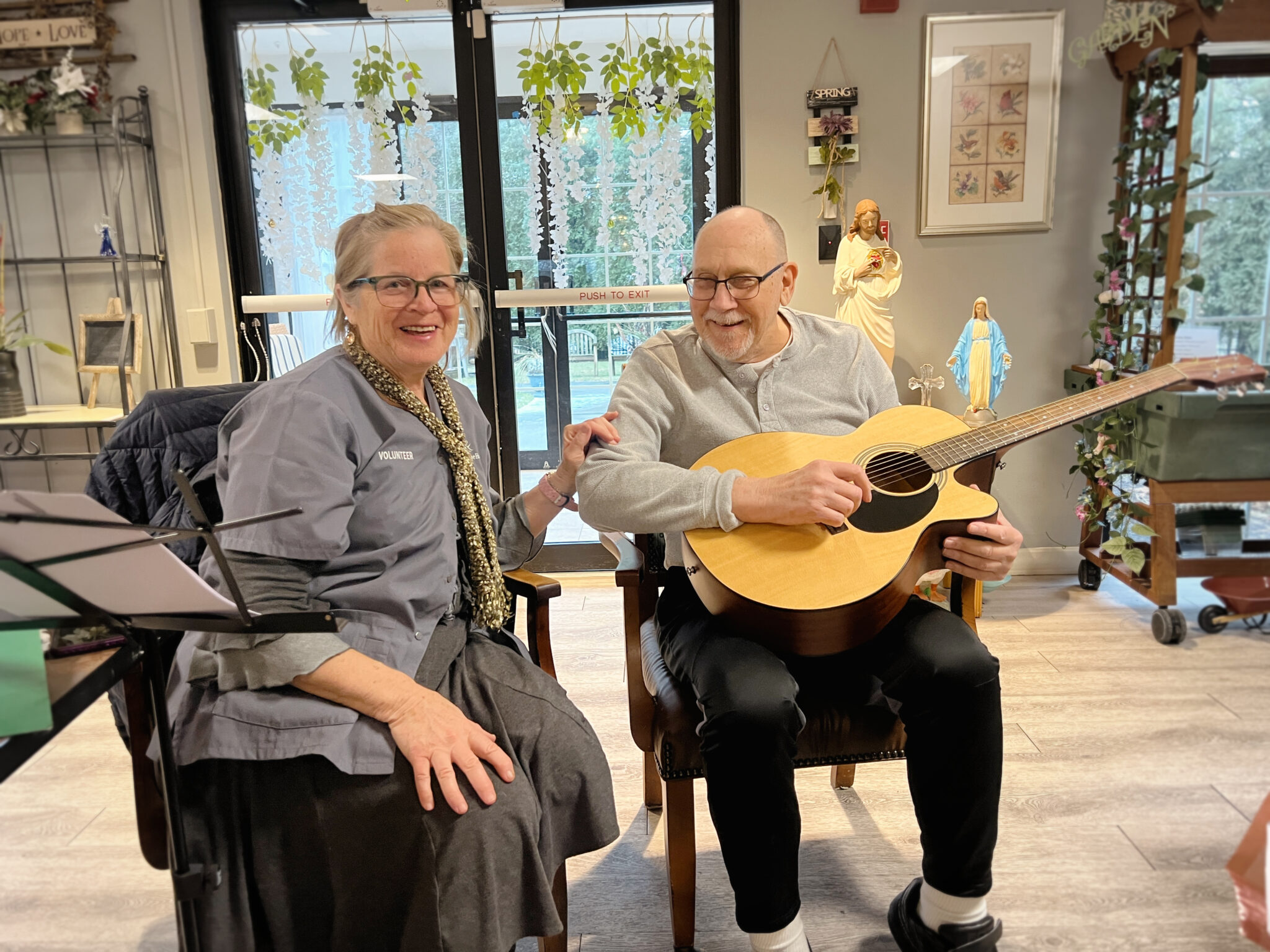Man and woman sitting. The man is holding a guitar.