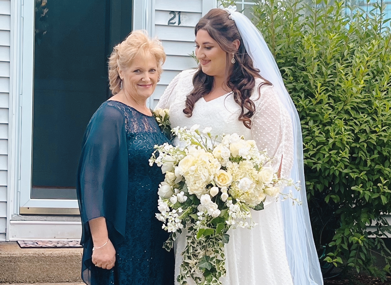 A bride looks down at her mother