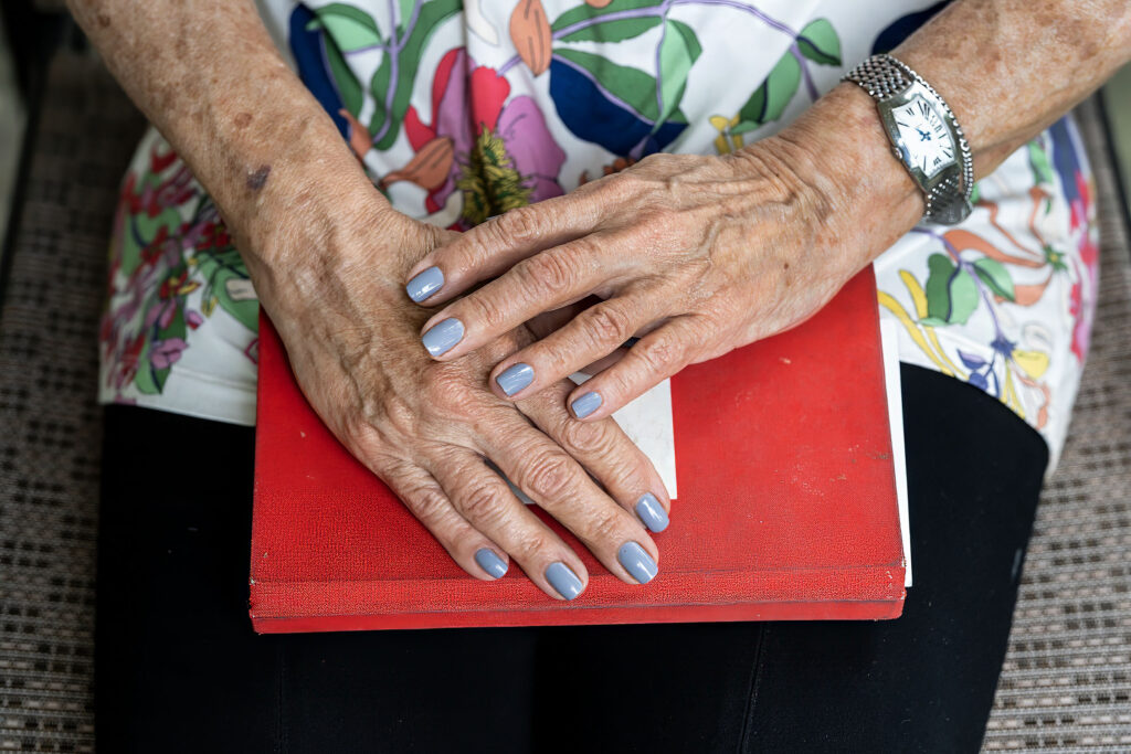 Hands resting on a red book