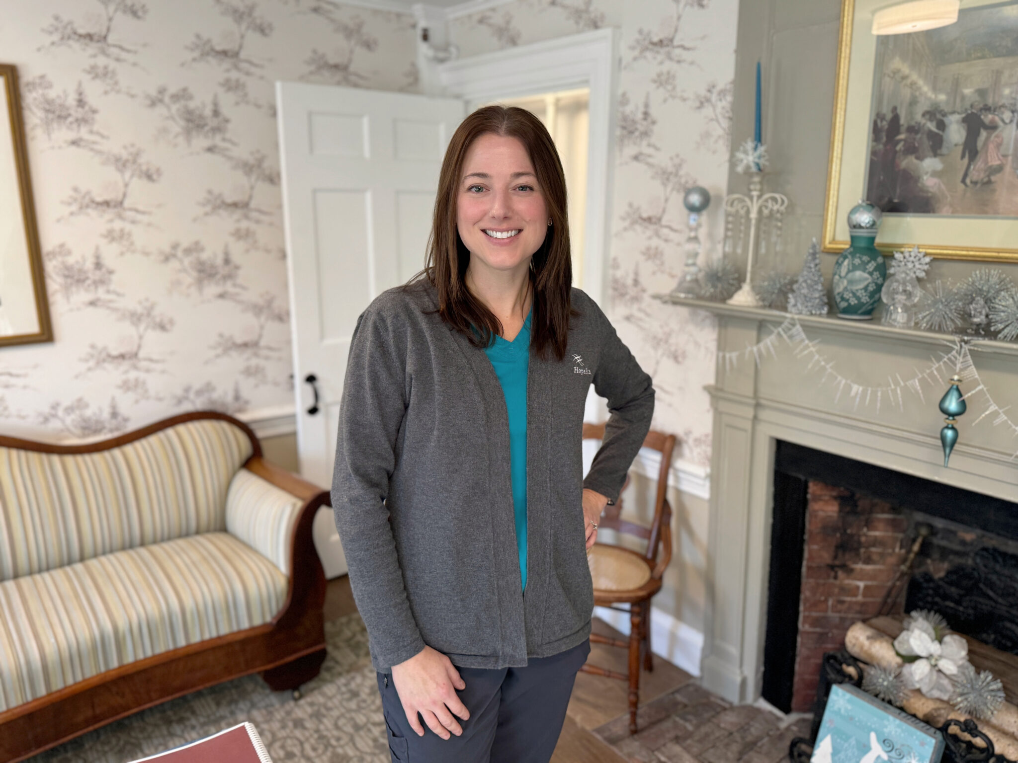 Nurse smiling in a room with a fireplace