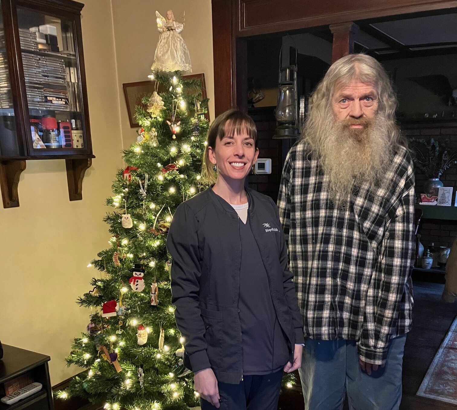 Man standing with nurse in front of Christmas tree