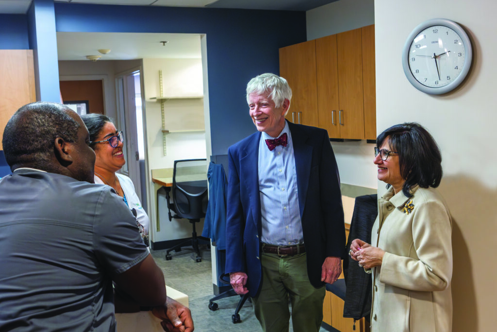 Four people standing in a nursing station talking