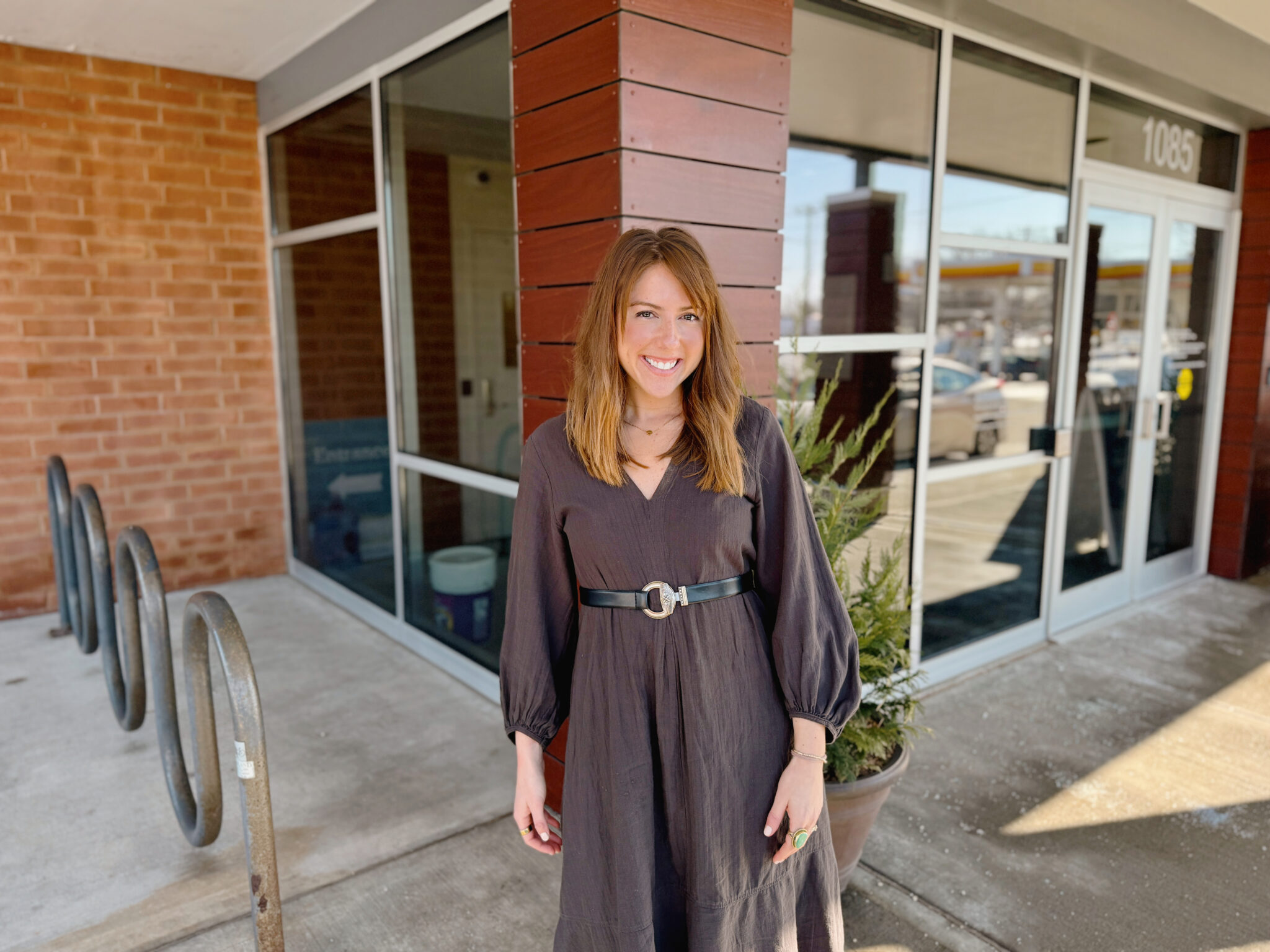 woman standing outside a brick building with large windows