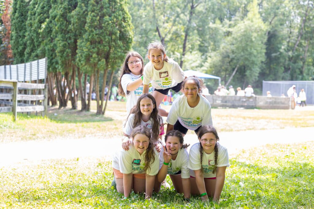 A group of girls stack to make a triangle during Camp BraveHeart