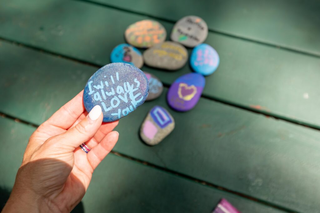 Painted stones with messages of remembrance with Camp BraveHeart
