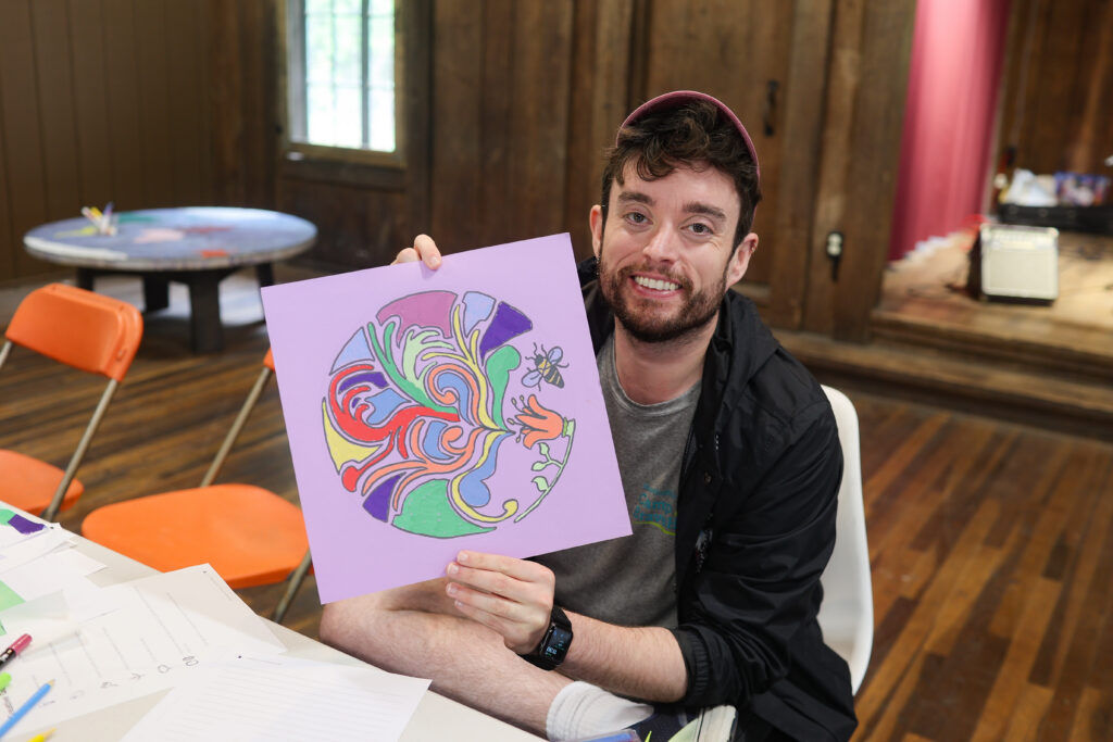 Male grief counselor holding up a drawing used for processing grief