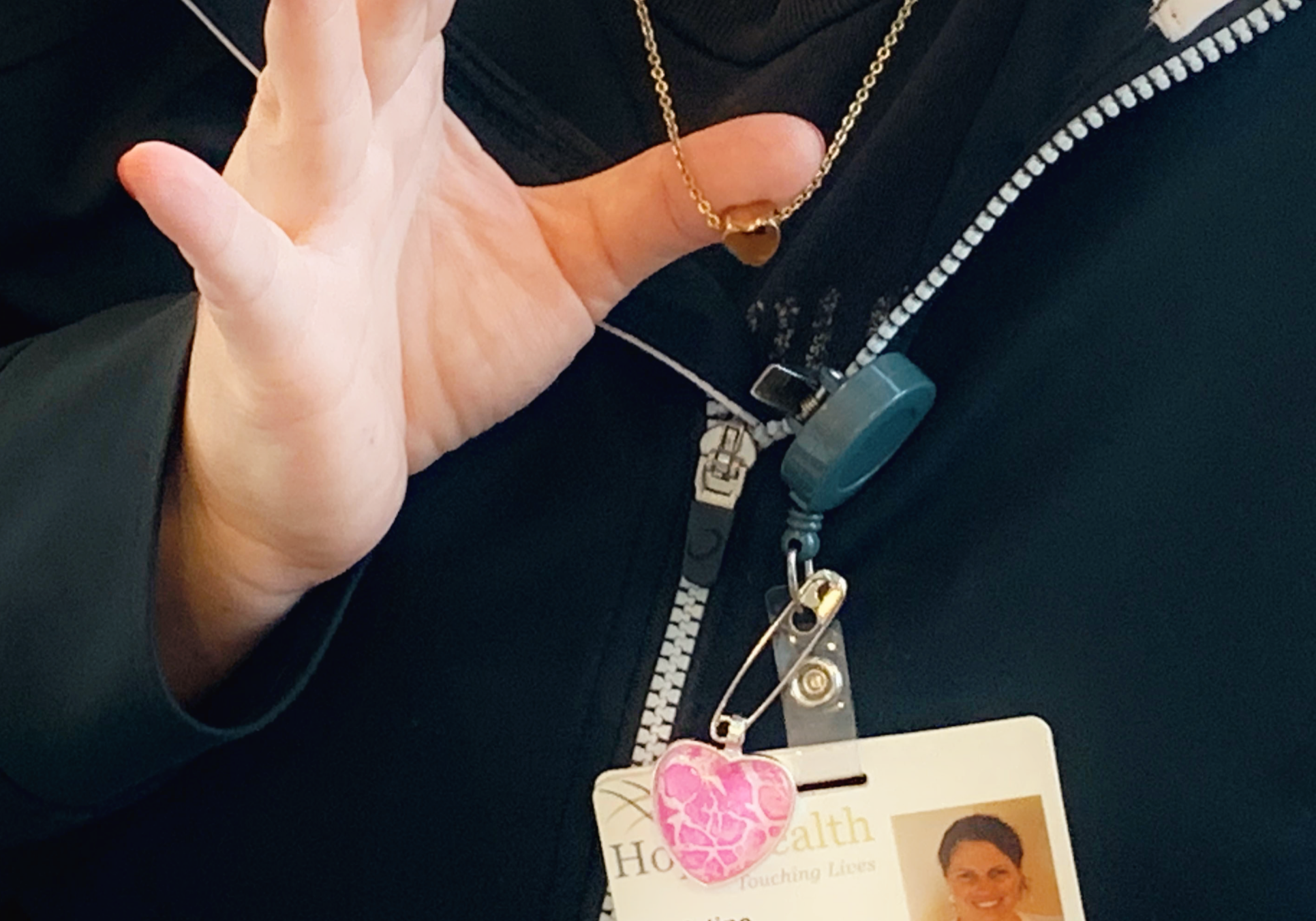 hospice doctor holds up her gold heart urn chain