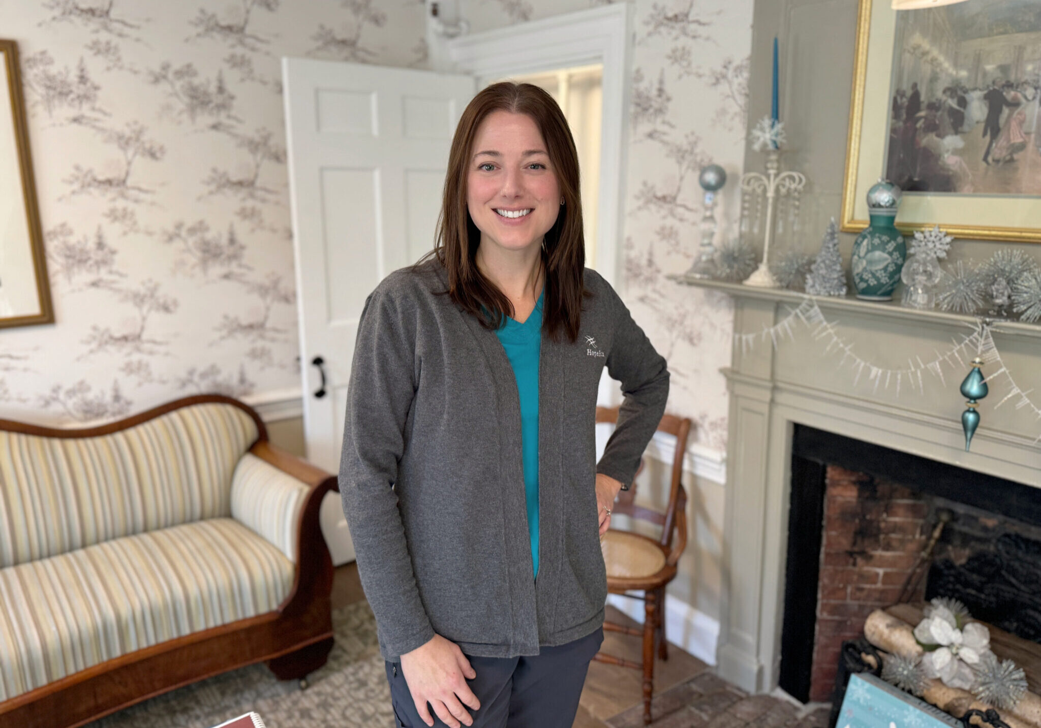 Nurse smiling in a room with a fireplace