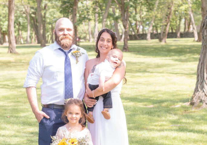 Mom and dad posing in the picturesque woods with their boy and girl