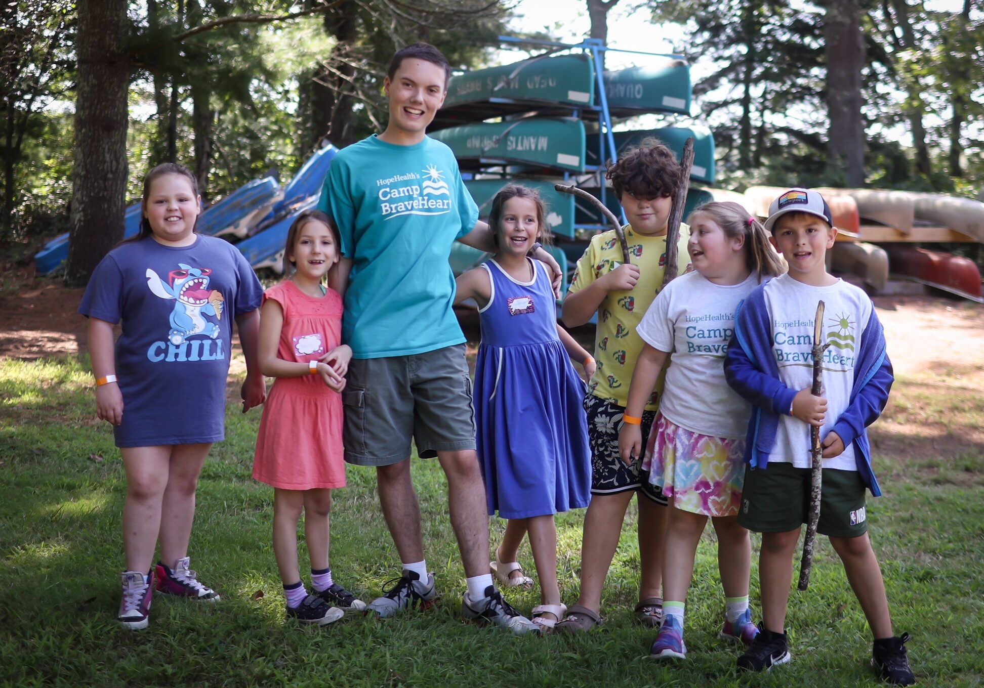 Camp Counselor standing with six young campers