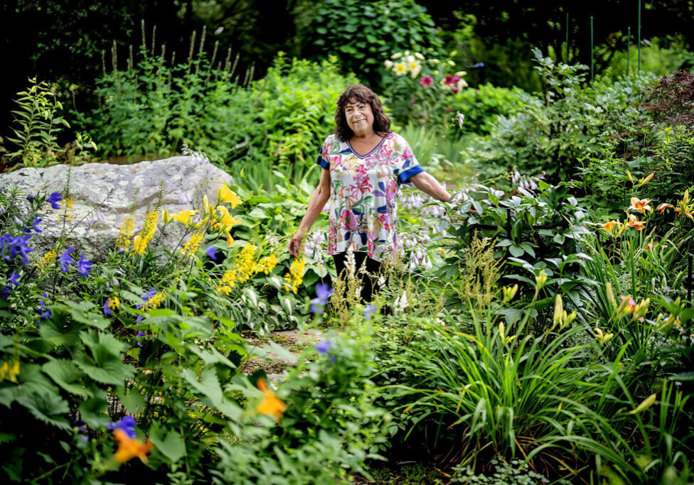 Woman standing amongst her garden
