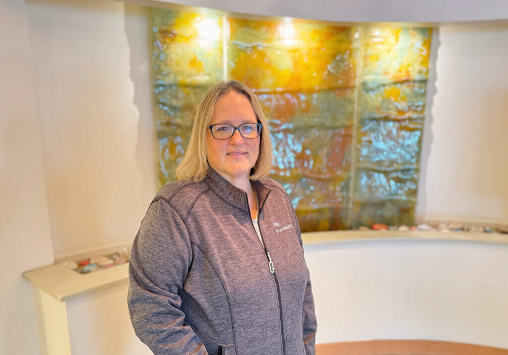 Female social worker standing in front of a earthy water display