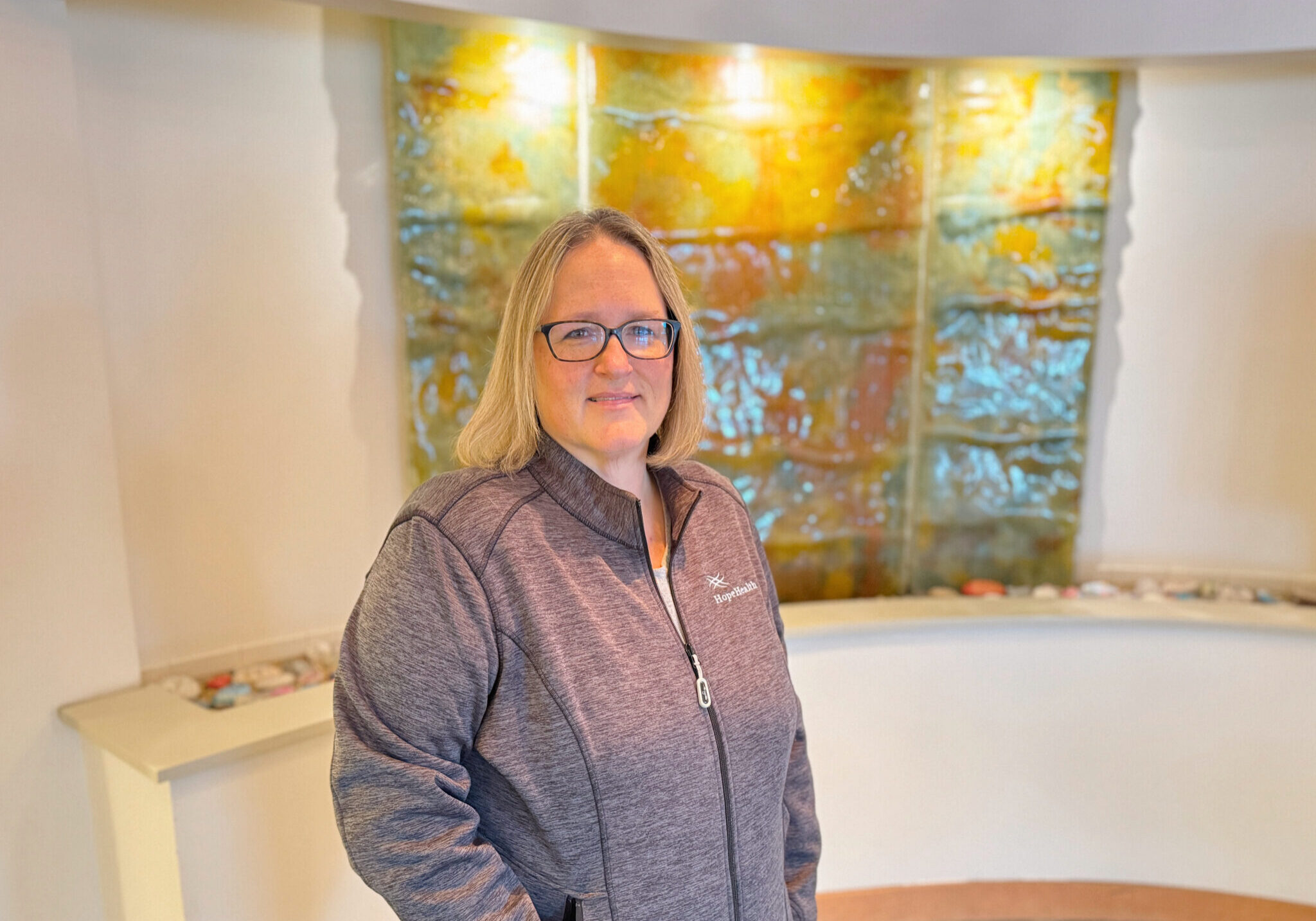 Female social worker standing in front of a earthy water display