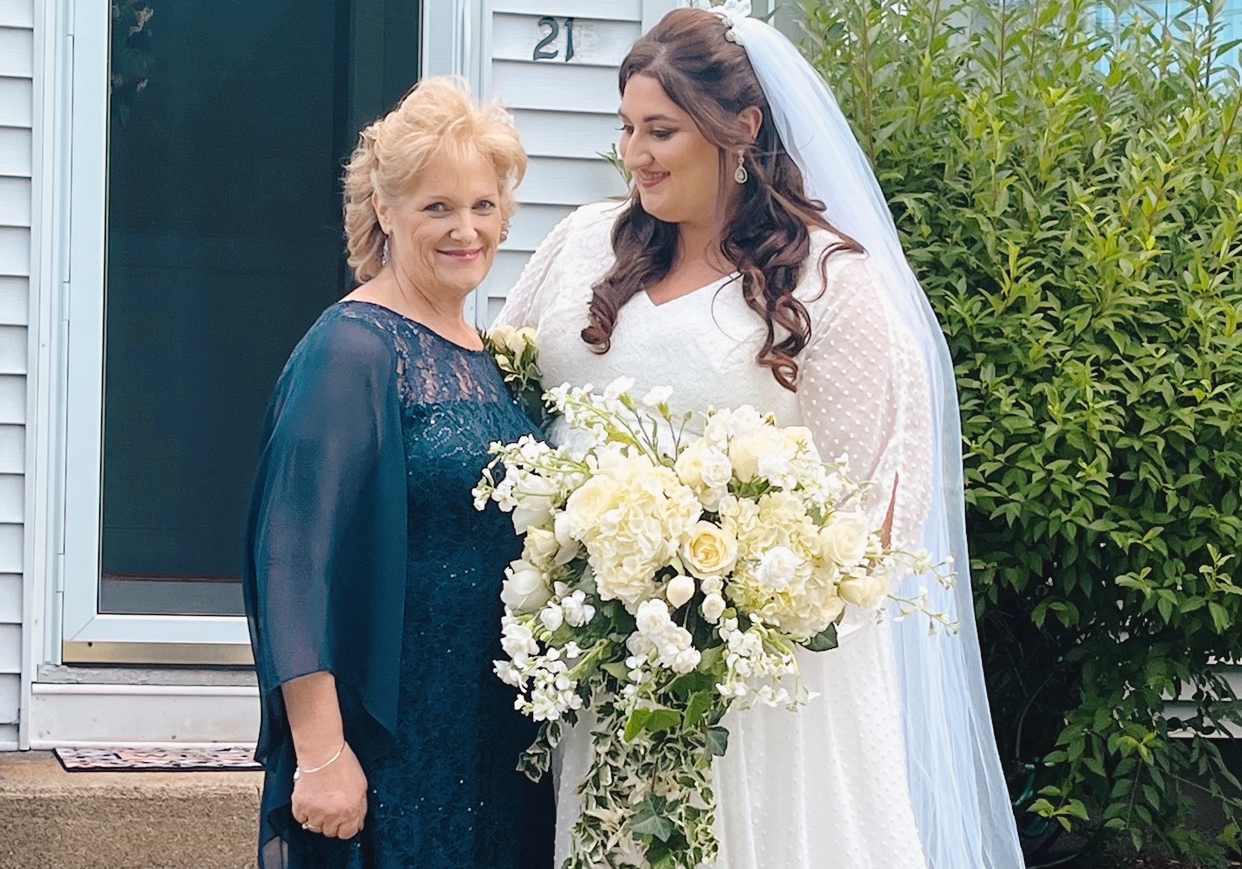 A bride looks down at her mother