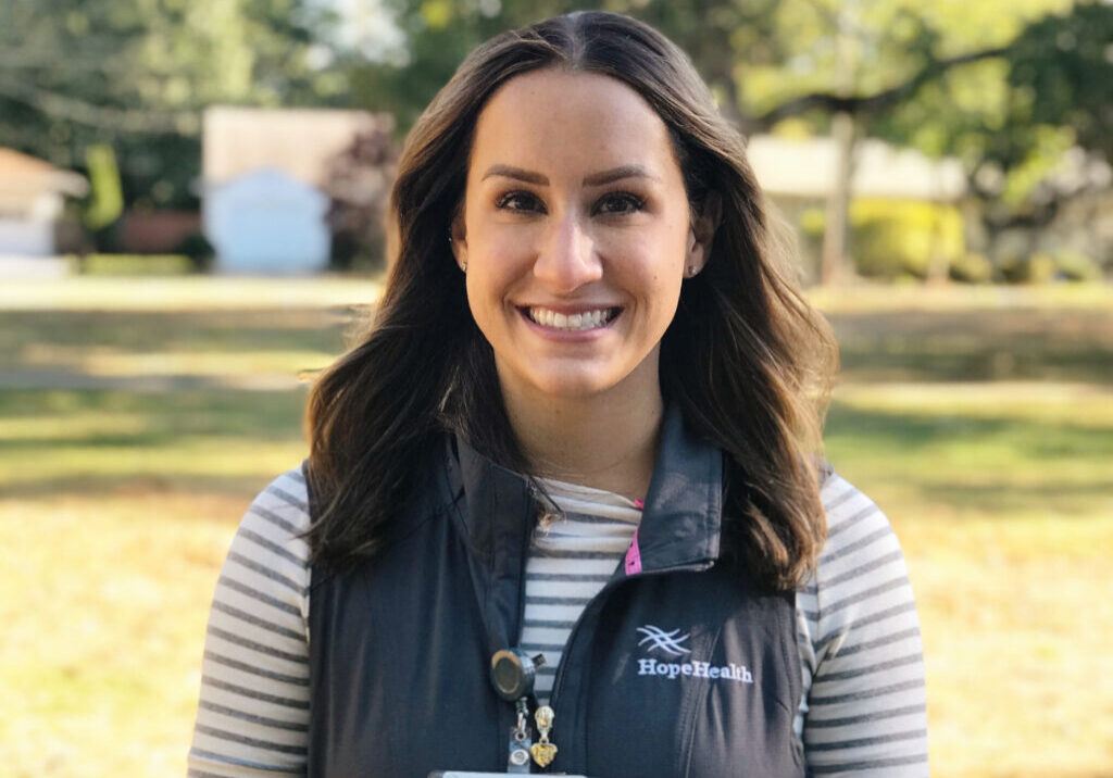 Palliative care nurse practitioner in a park wearing vest and badge