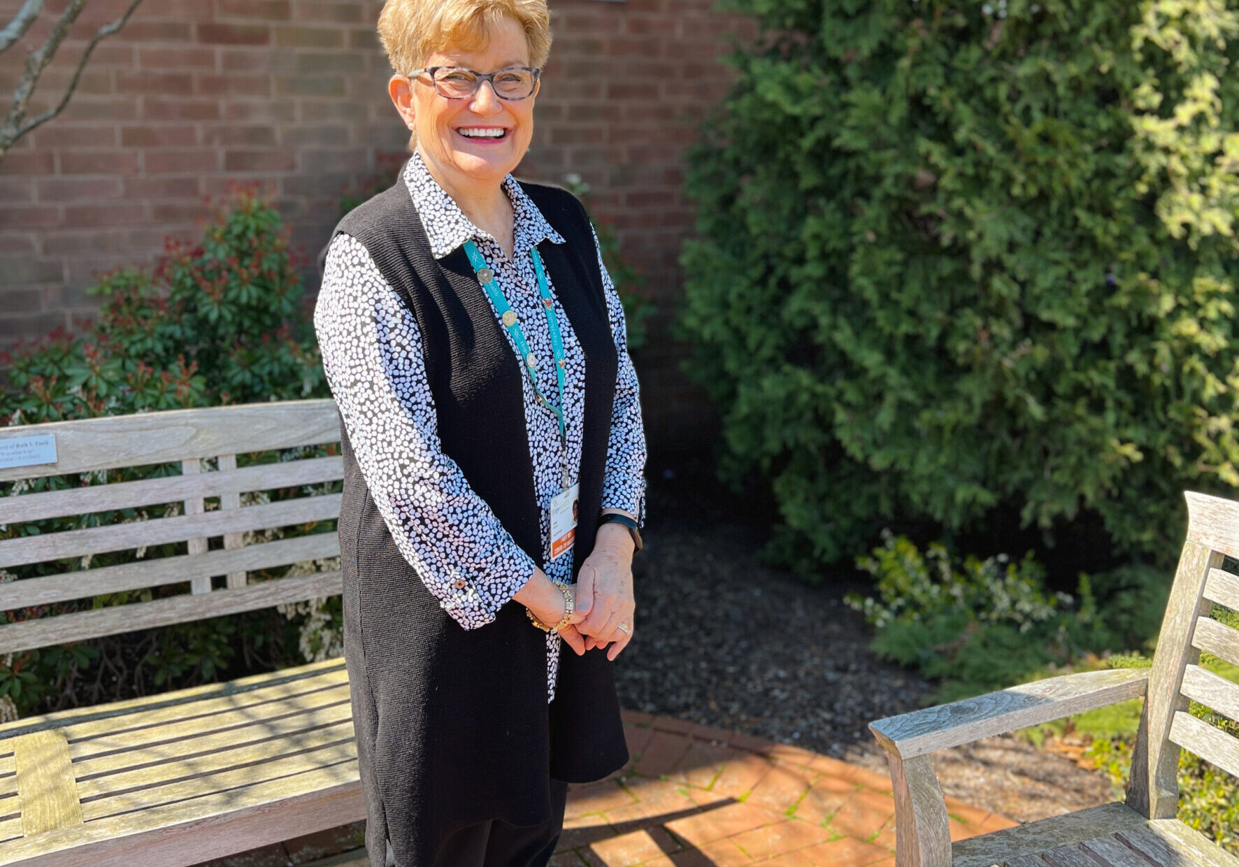 Woman standing in a brick pathed garden