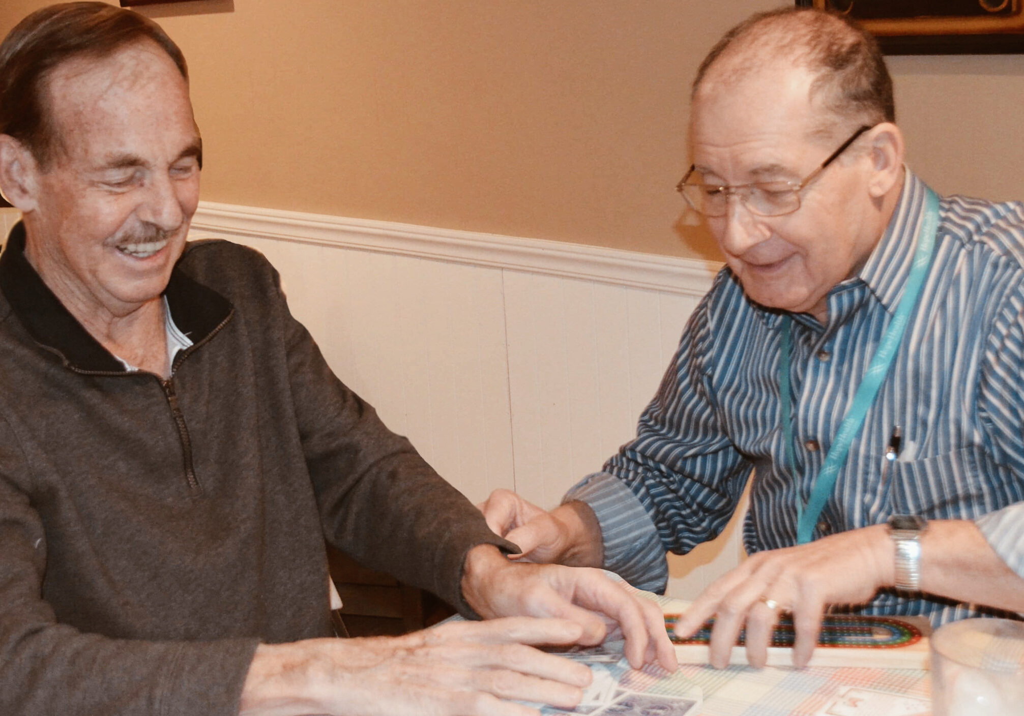 two men playing cards at table