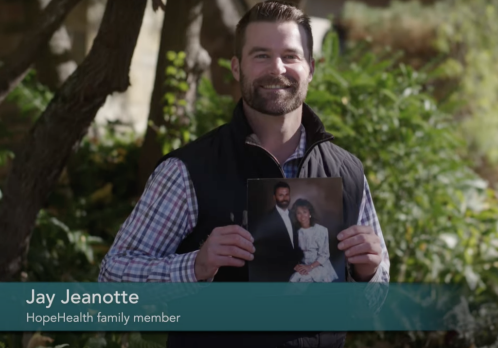 Screenshot 2023-07-17 at 2.46.21 PM Photo of a man holding up a photo of his parents