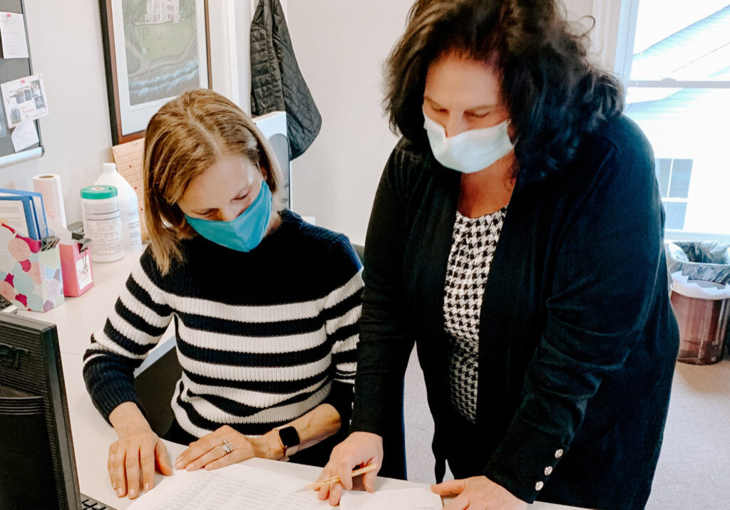 Volunteer Elayne Casey, left, with Administrative Assistant Ann Seaback in HopeHealth's Wakefield office.