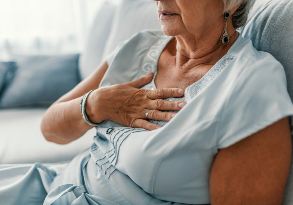 older woman holding chest