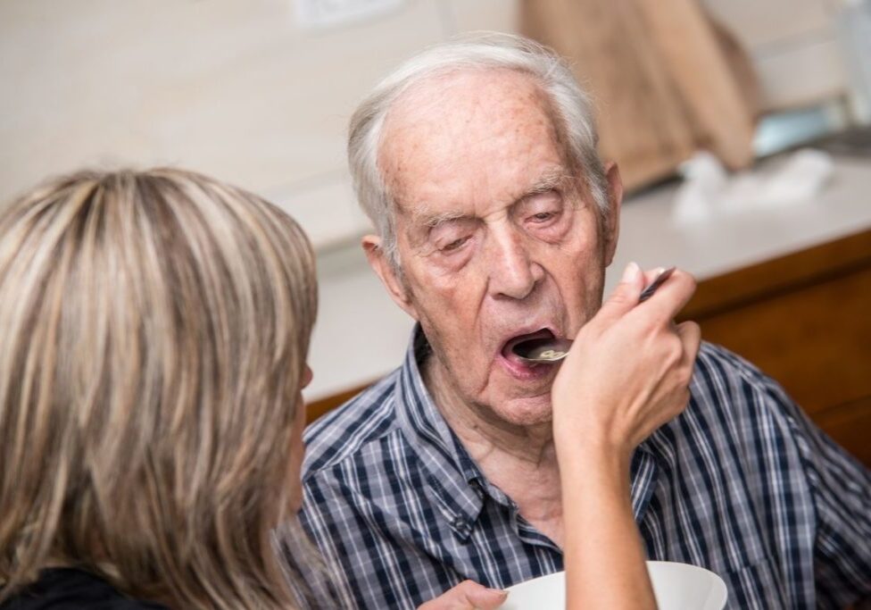 old man opening mouth for spoonful of foodto eat spoonful of food