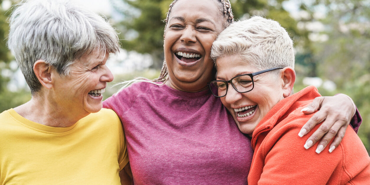 Three elderly woman hugging after workout