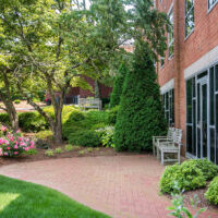 Memorial brick garden with lovely rose bushes and big green trees surrounding it