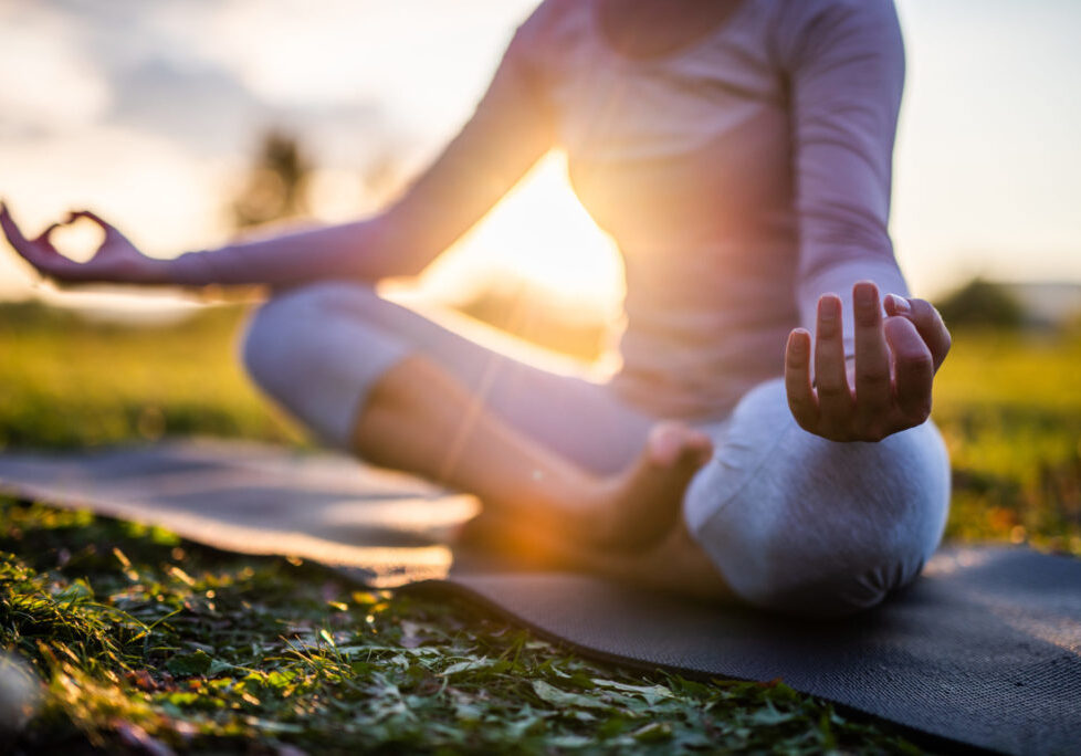 Close up of meditation in park at sunrise. Close up of yoga outdoor at sunset.