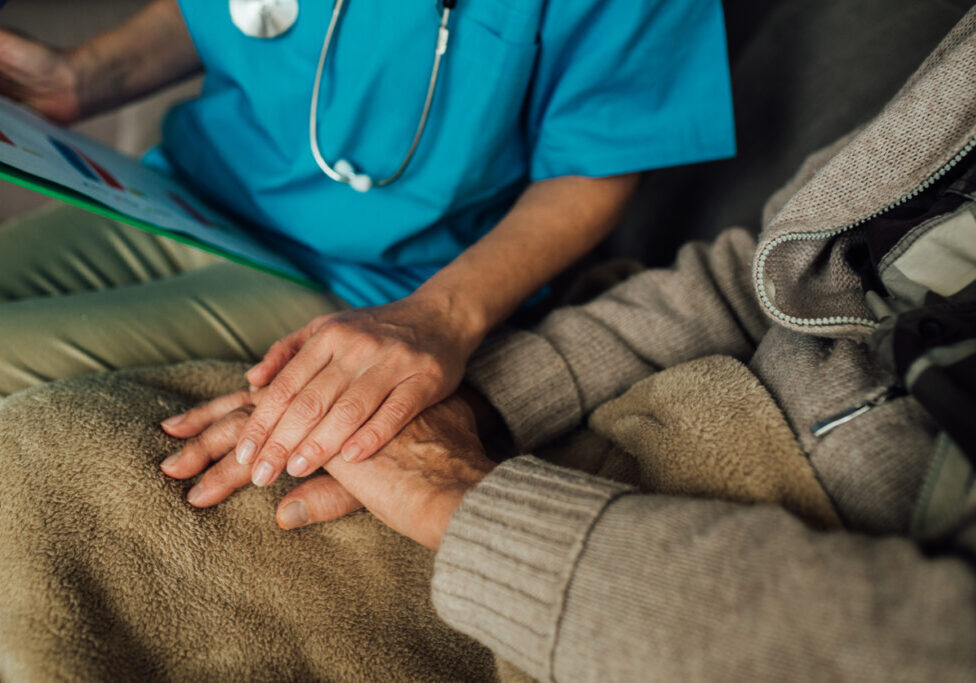 Male patient holding hands with a nurse