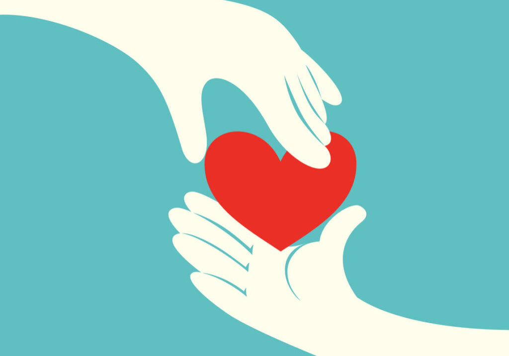 Close up of hand giving a red heart to another hand on green background
