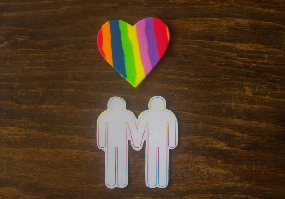 gay couple and a multicolored heart - closeup gay couple and a multicolored heart - closeup