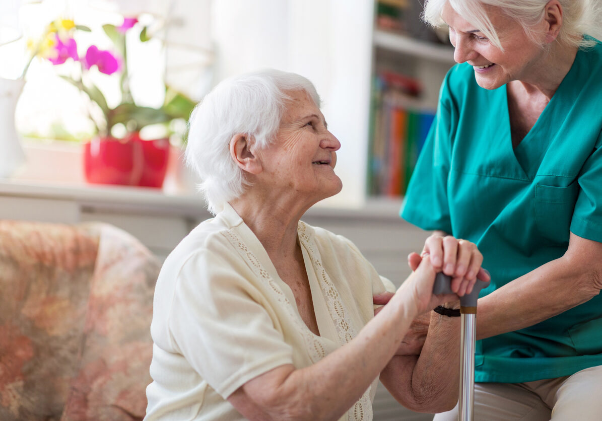 Female nurse standing and her senior female patient