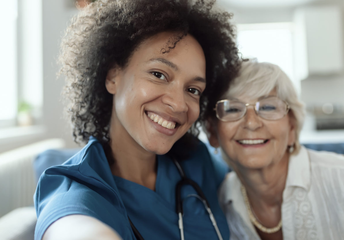 Palliative care nurse smiling with elderly patient