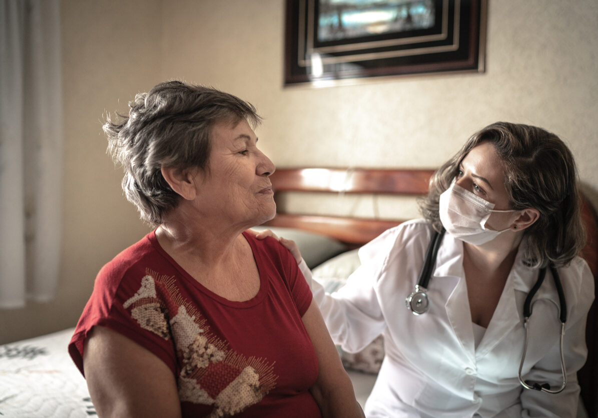 Health visitor talking to a senior woman during home visit