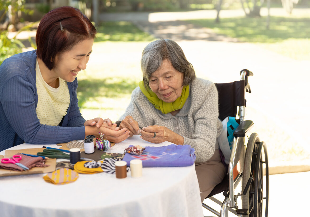 Elderly woman and daughter in the needle crafts occupational therapy for Alzheimer’s or dementia