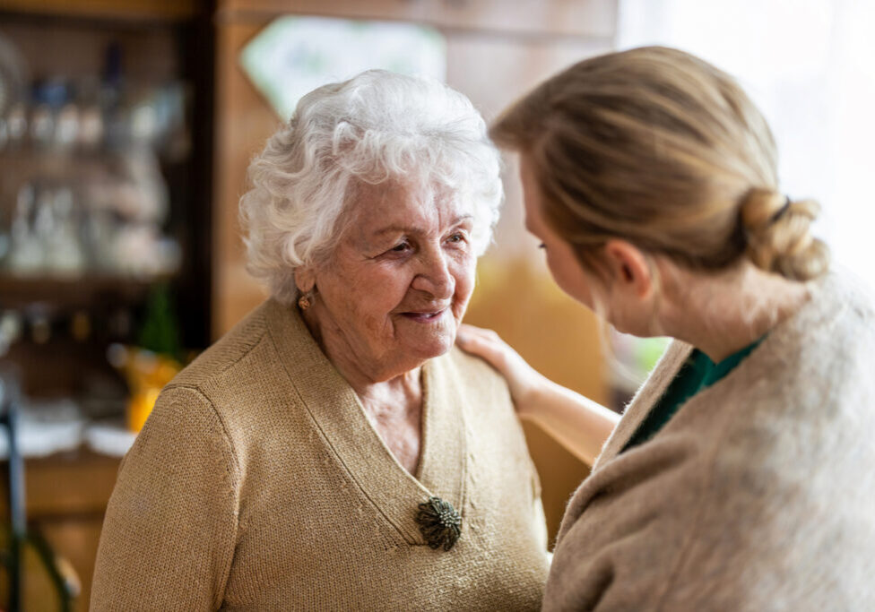 Health visitor talking to a senior woman during home visit