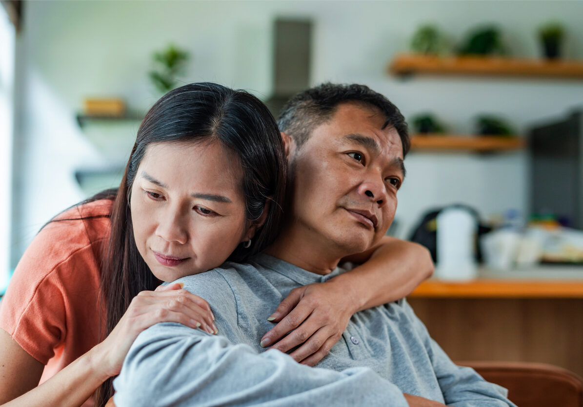Woman expressing empathy and compassion, encouraging husband man with prosthetic leg at home